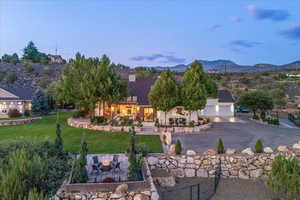 View of front of house with a front yard, a mountain view, a garage, and driveway