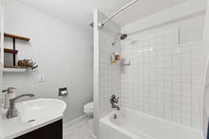 Full bathroom with porcelain marble finish floors, shower / bath combo