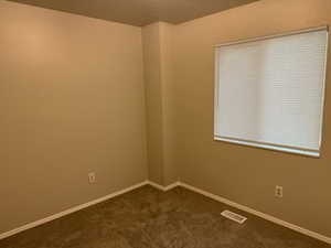 Bedroom with dark carpet and baseboards