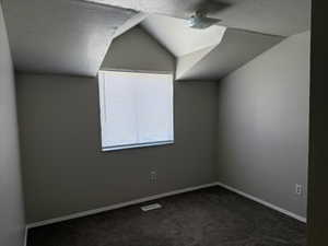 Bedroom with vaulted ceiling and carpet