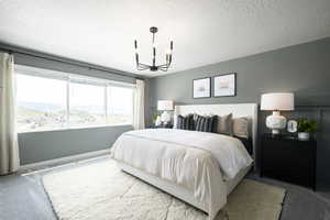 Bedroom featuring carpet floors, a chandelier, and a textured ceiling