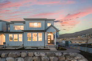 Back of property at dusk with board and batten siding and a mountain view