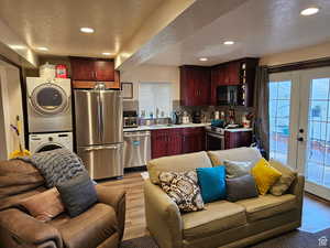 Kitchen featuring appliances with stainless steel finishes, stacked washer / drying machine, open floor plan, french doors, and recessed lighting