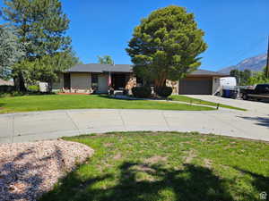 View of front facade with concrete driveway, a garage, and a mountain view