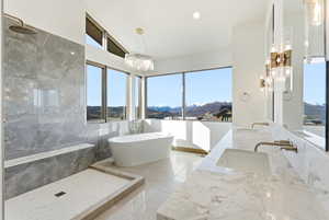 Full bath featuring a mountain view, double vanity, a freestanding tub, a marble finish shower, and recessed lighting