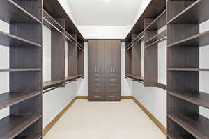 Walk in closet with light colored carpet
