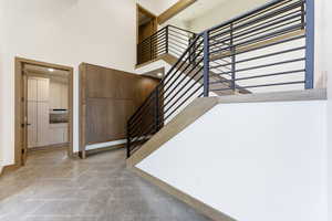 Stairs featuring a high ceiling and baseboards
