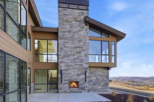 View of patio with an outdoor stone fireplace and a mountain view