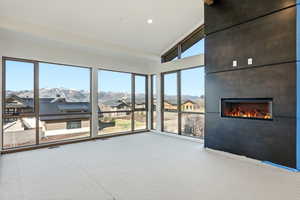 Unfurnished sunroom with vaulted ceiling, a residential view, and a mountain view