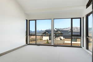 Unfurnished room with a mountain view, carpet flooring, and vaulted ceiling
