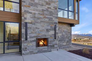 Exterior view of an outdoor stone fireplace and stone siding