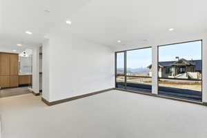 Spare room featuring light carpet, a mountain view, and recessed lighting