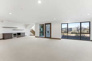 Unfurnished living room with light carpet and recessed lighting