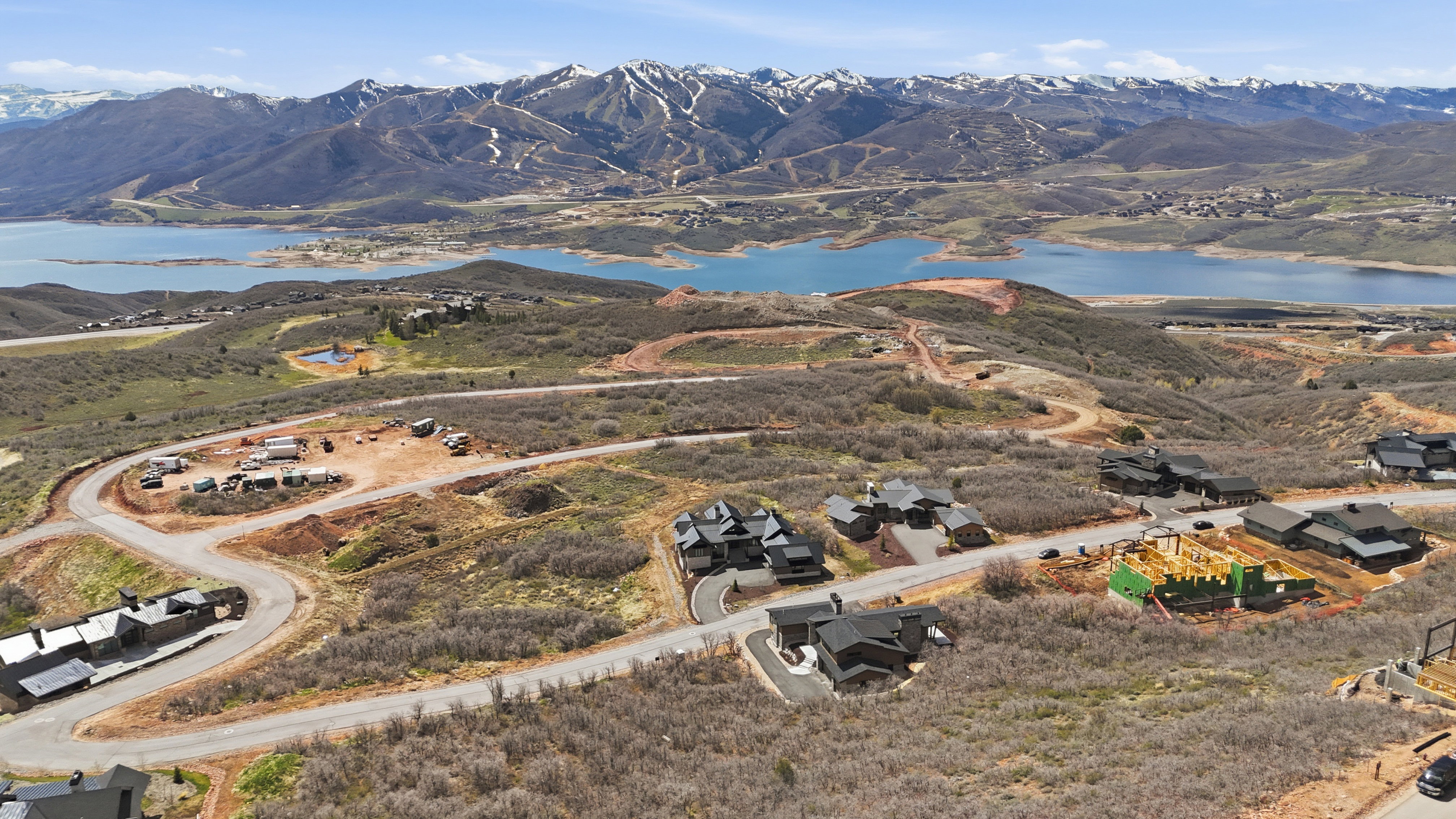 Aerial view of property and surrounding area featuring a water and mountain view and nearby suburban area