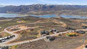 Aerial view of property and surrounding area featuring a water and mountain view and nearby suburban area
