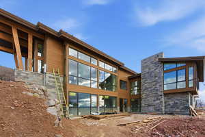 Back of house featuring stone siding