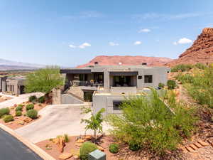 View of front of house with stucco siding, a mountain view, and driveway