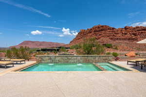 Outdoor pool featuring a mountain view, a patio, and an in-ground hot tub