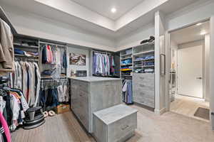 Spacious closet featuring washer and dryer and light carpet