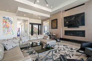 Living room featuring wood finished floors, a tiled fireplace, and recessed lighting