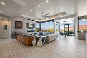 Living area featuring a ceiling fan, a tray ceiling, and recessed lighting