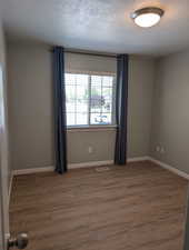 Empty room with wood finished floors and baseboards