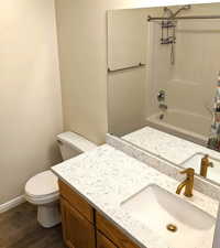 Full bath with wood finished floors and vanity