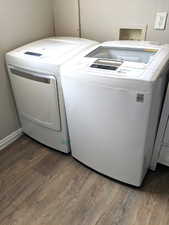 Laundry area featuring washer and dryer and wood finished floors