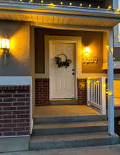 Property entrance featuring brick siding and stucco siding