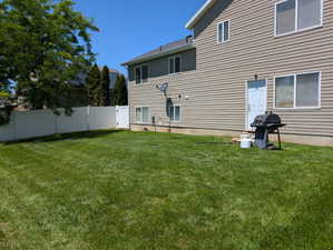 Rear view of property with a fenced backyard
