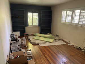 Bedroom with wood finished floors and baseboards