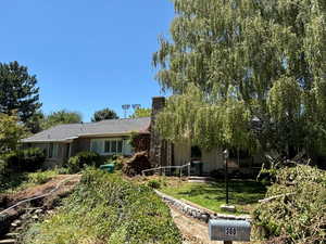 View of front of house with a front lawn, brick siding, and a chimney