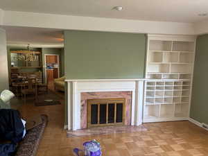 Unfurnished living room featuring a chandelier, a premium fireplace, and recessed lighting