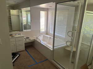 Bathroom featuring a whirlpool tub, a shower stall, and vanity