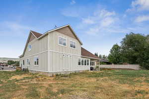 Rear view of house with board and batten siding and roof with shingles