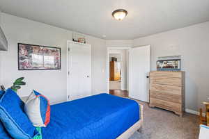 Bedroom featuring baseboards and light carpet