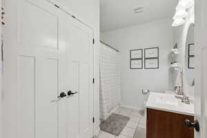 Full bath with tile patterned flooring, vanity, and a shower with shower curtain