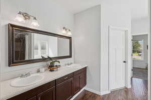 Bathroom featuring double vanity, wood finished floors, and a shower