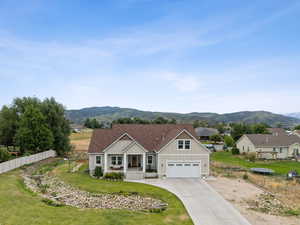 View of front of property with covered porch, concrete driveway, a mountain view, and a garage