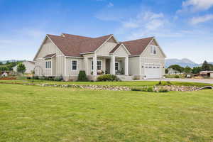 View of front of home featuring board and batten siding, a mountain view, driveway, covered porch, and an attached garage