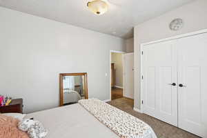 Carpeted bedroom featuring a closet and baseboards