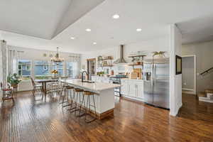 Kitchen with stainless steel appliances, open shelves, dark wood-style floors, recessed lighting, and light countertops