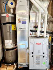 Utility room featuring water heater and heating unit