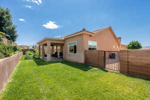Back of house featuring a fenced backyard, stucco siding, a patio area, a gate, and a tiled roof