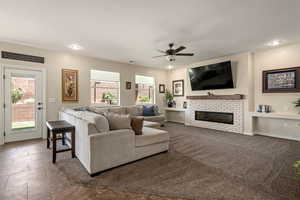 Living area featuring ceiling fan, a fireplace, and recessed lighting