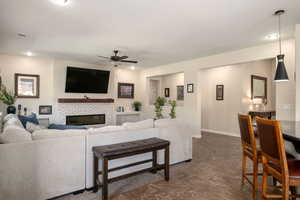 Living room with ceiling fan, a brick fireplace, and recessed lighting