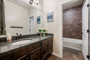 Full bathroom with vanity, washtub / shower combination, and marble finish flooring