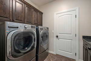 Washroom featuring cabinet space and washing machine and dryer