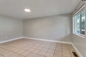 Empty room with baseboards and light tile patterned floors