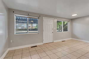 Unfurnished room featuring light tile patterned floors